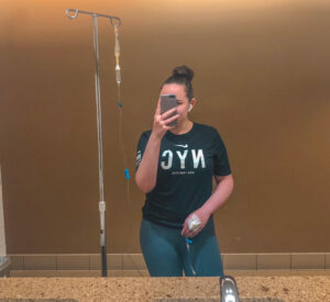 Image of Brooklyn hooked up to an IV in a t-shirt and leggings